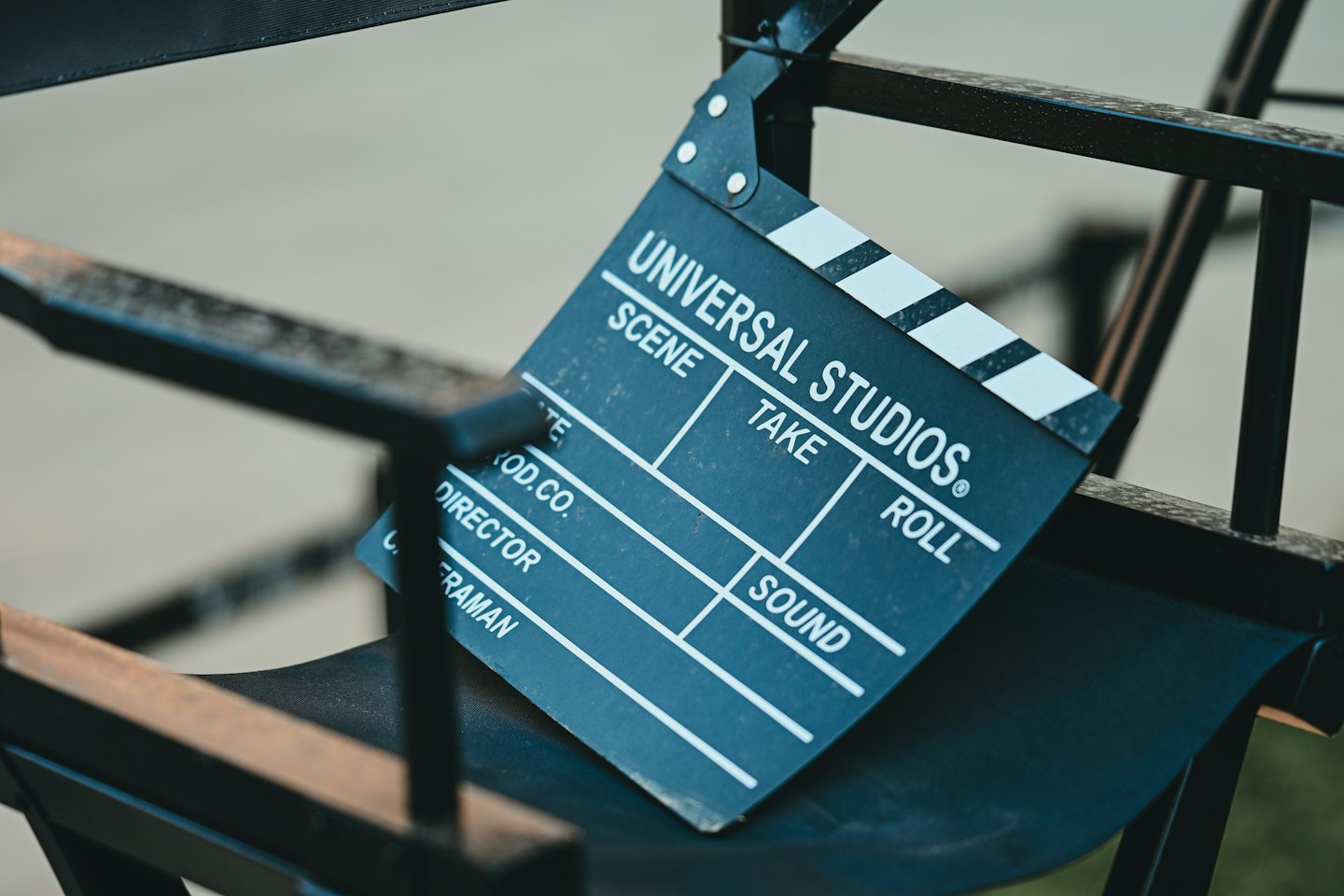 Film clapperboard resting on a black director's chair.